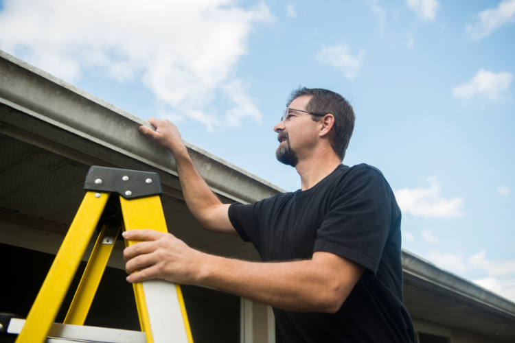 Homeowner documenting roof damage after a storm.